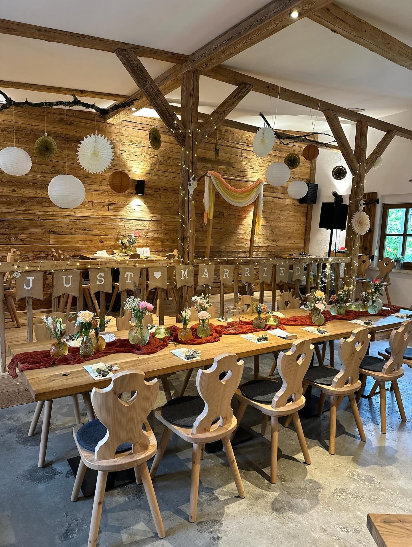 Festlich mit Lampions und Lichterketten geschmückte Alm mit Just-Married-Girlande