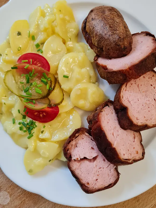 Ofenfrischer Leberkäse mit fränkischem Kartoffelsalat, Tomate und Gurke