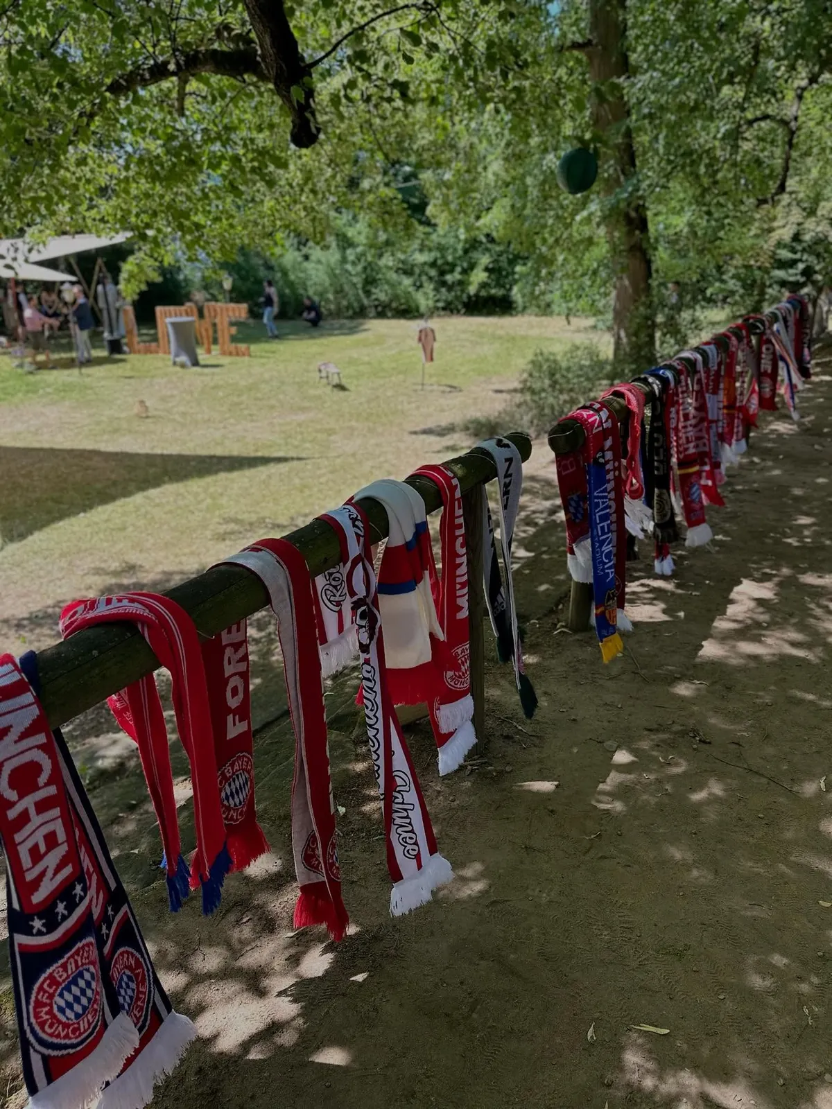 Fußballschals in Rot-Weiß am Holzzaun der Wiese – Mottohochzeit auf dem Dercks'n Berch