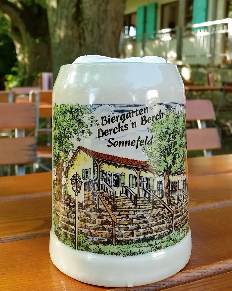 Steinkrug mit der Zeichnung des Biergartens Dercks'n Berch auf einem Biertisch unter den Linden